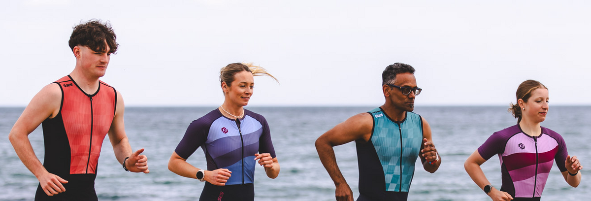 Triathletes competing in a race while wearing sleeved and sleeveless triathlon suits, highlighting different race-day apparel choices.